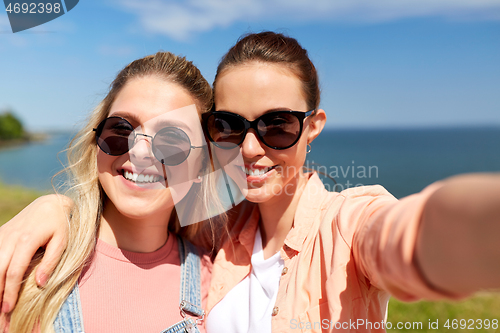 Image of teenage girls or friends taking selfie in summer