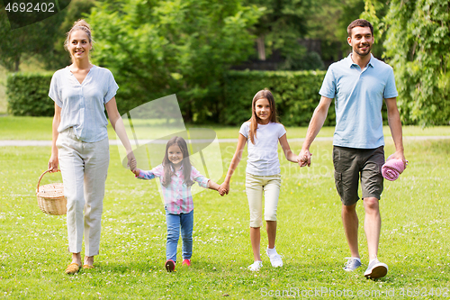 Image of family with picnic basket walking in summer park