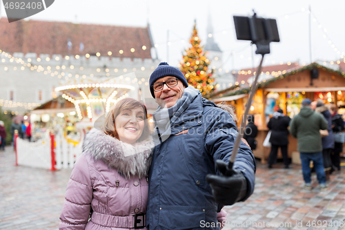 Image of senior couple taking selfie at christmas market