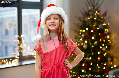 Image of happy red haired girl in santa helper hat at home