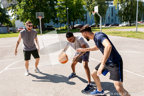 Image of group of male friends playing street basketball