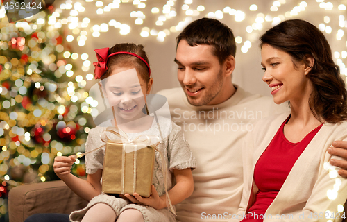 Image of happy family with christmas present at home