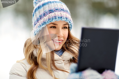 Image of woman with tablet computer outdoors in winter