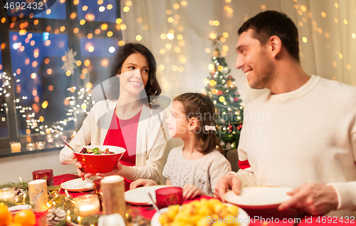 Image of happy family having christmas dinner at home