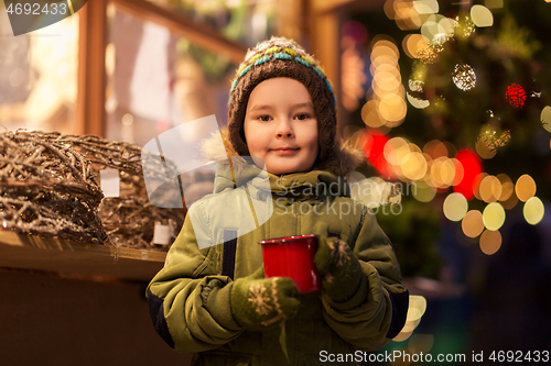 Image of happy boy with cup of tea at christmas market