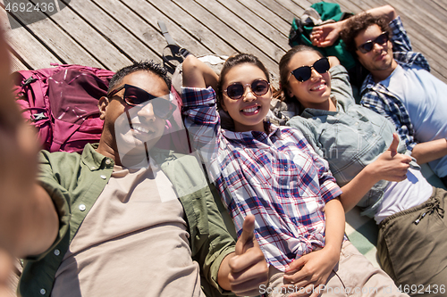 Image of friends or tourists with backpacks taking selfie