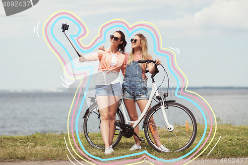 Image of teenage girls with bicycle taking selfie in summer