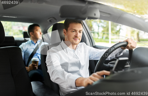 Image of male driver driving car with passenger