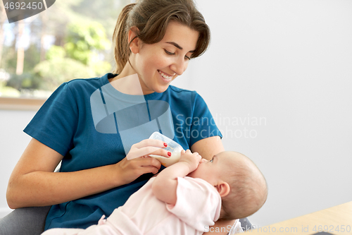 Image of mother feeding baby daughter with milk formula