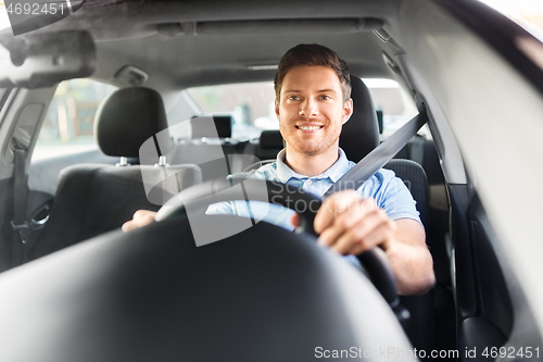 Image of smiling man or driver driving car