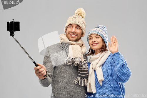 Image of happy couple in winter clothes taking selfie