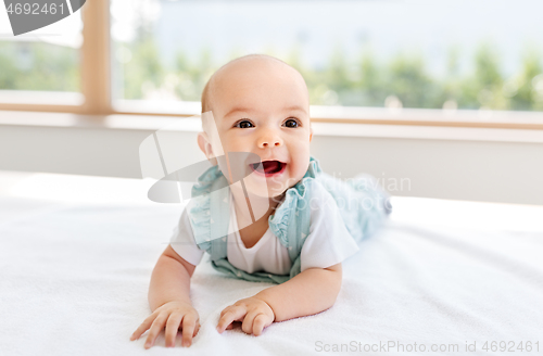 Image of sweet baby girl lying on white blanket