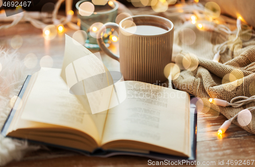 Image of book and cup of coffee or hot chocolate on table