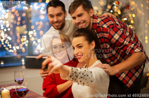 Image of friends taking selfie at christmas dinner