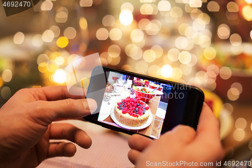 Image of hands photographing food at christmas dinner