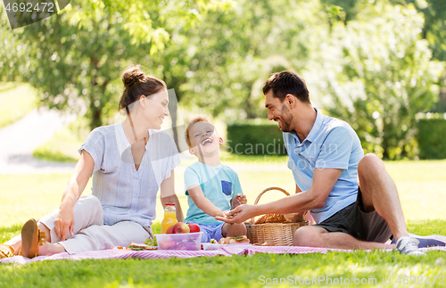 Image of happy family having picnic at summer park