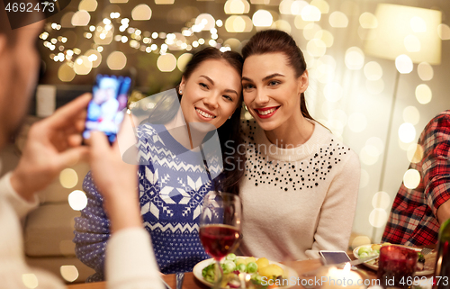 Image of friends having christmas dinner and taking picture