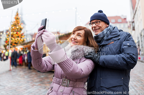 Image of senior couple taking selfie at christmas market