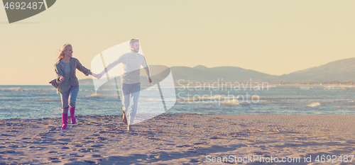 Image of Loving young couple on a beach at autumn sunny day