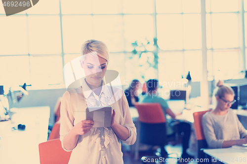 Image of woman working on digital tablet in night office