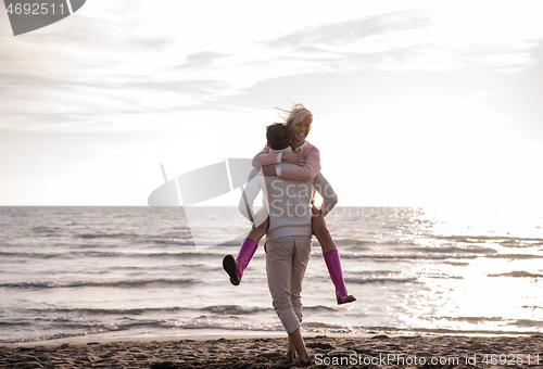 Image of Loving young couple on a beach at autumn sunny day