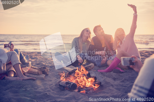 Image of Friends having fun at beach on autumn day