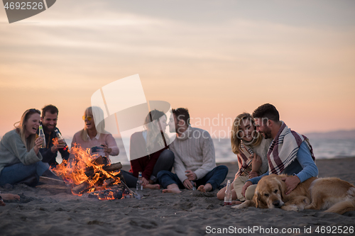 Image of Friends having fun at beach on autumn day