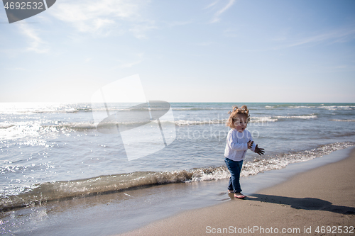 Image of cute little girl at autumn beach