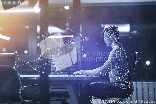 Image of man working on laptop in dark office