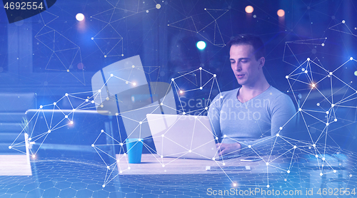 Image of man working on laptop in dark office