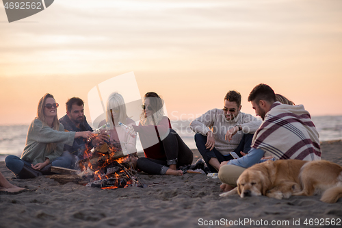 Image of Friends having fun at beach on autumn day