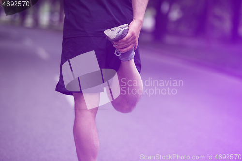 Image of male runner warming up and stretching before morning training