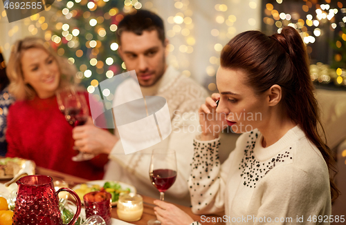 Image of woman calling on smartphone at christmas dinner