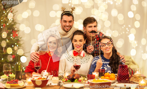 Image of happy friends celebrating christmas at home