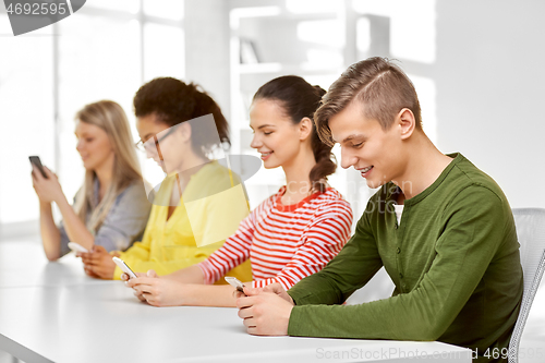 Image of happy high school students with smartphones