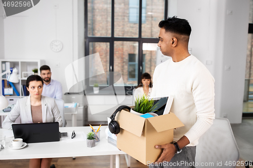 Image of sad fired male office worker with personal stuff