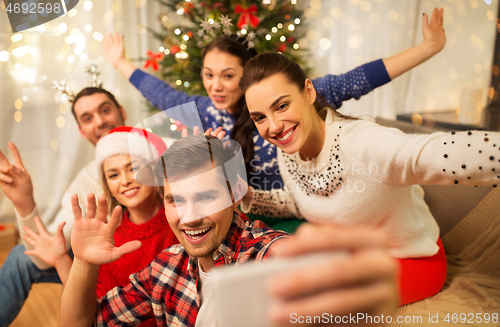 Image of friends celebrating christmas and taking selfie