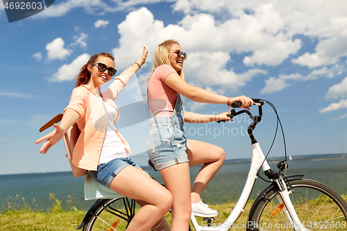 Image of teenage girls or friends riding bicycle in summer