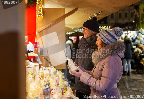 Image of happy senior couple hugging at christmas market