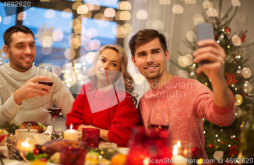 Image of friends taking selfie at christmas dinner