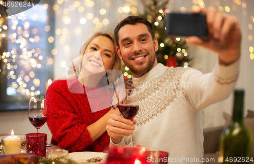 Image of happy couple taking selfie at christmas dinner