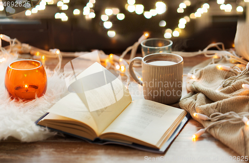 Image of book and coffee or hot chocolate on window sill