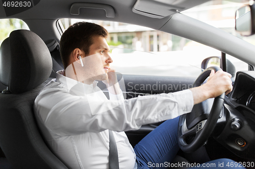 Image of man or driver with wireless earphones driving car