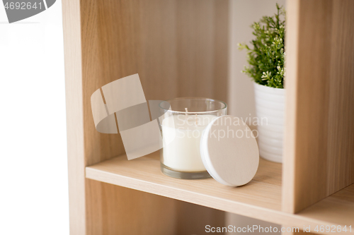 Image of fragrance candle in glass holder on shelving