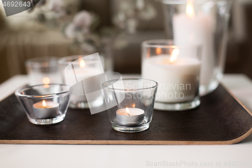 Image of burning fragrance candles on table at cozy home