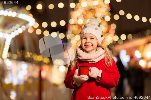 Image of happy girl with cup of tea at christmas market