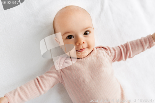 Image of sweet baby girl lying on white blanket
