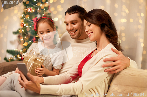 Image of family with smartphone at home on christmas