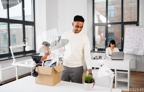 Image of happy male office worker with personal stuff