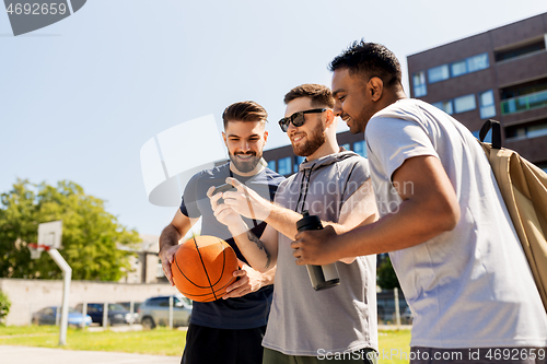 Image of men with smartphone at basketball playground